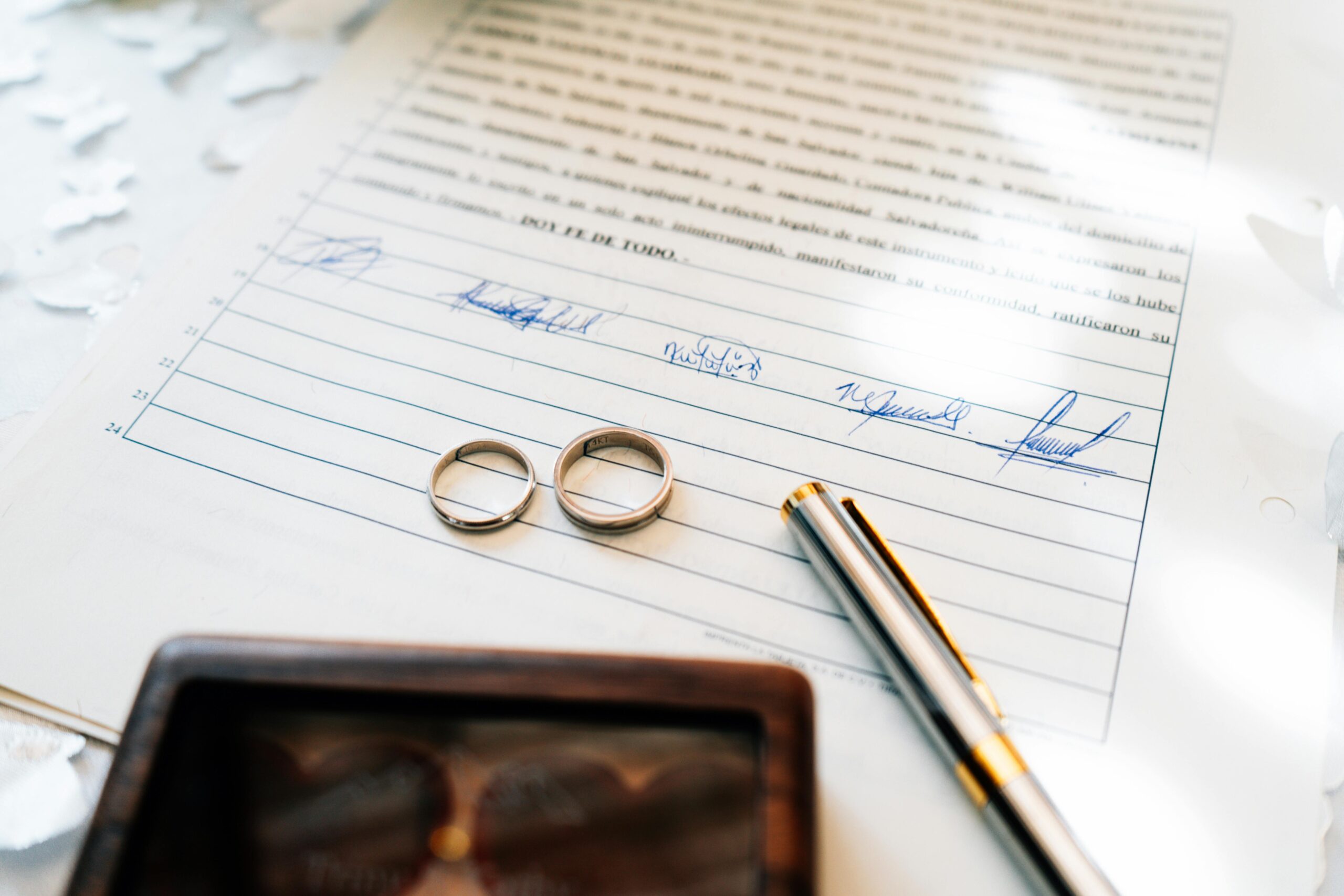 Wedding rings on signed legal document representing postnuptial agreement in North Carolina